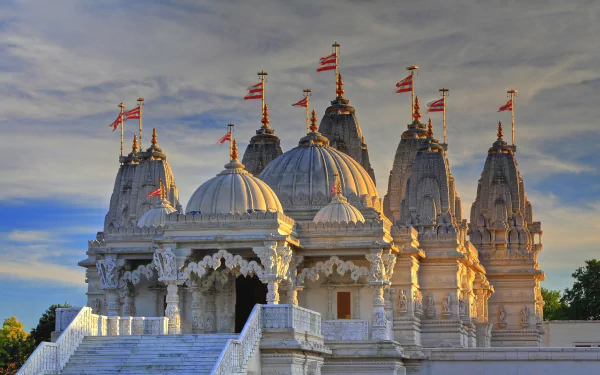 HD desktop wallpaper featuring the Shri Swaminarayan Mandir, a religious temple in London, England, under a dramatic sky at sunset.