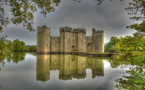 HD desktop wallpaper showcasing the man-made Bodiam Castle surrounded by a reflective moat and lush greenery under a cloudy sky.