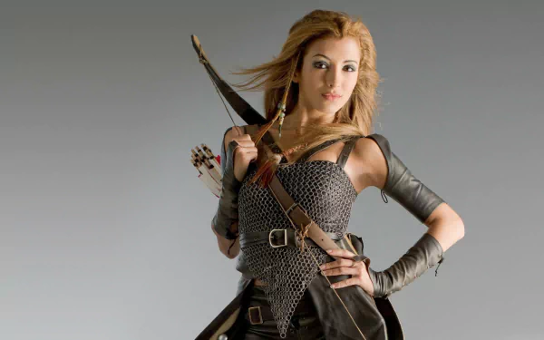 An HD wallpaper featuring India de Beaufort as a warrior in Kröd Mändoon and the Flaming Sword of Fire, showcasing her in armor with a bow and arrows.