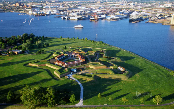 Aerial HD desktop wallpaper of a man-made star-shaped fort surrounded by green land, with a bustling city and harbor in the background.