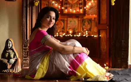 Bollywood actress Tamannaah Bhatia captures attention in this HD desktop wallpaper, radiating elegance in a vibrant saree against a beautifully decorated backdrop.