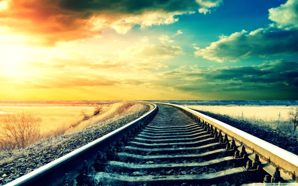 HD desktop wallpaper featuring a man-made railroad curving through a snowy landscape under a vibrant sunset sky.