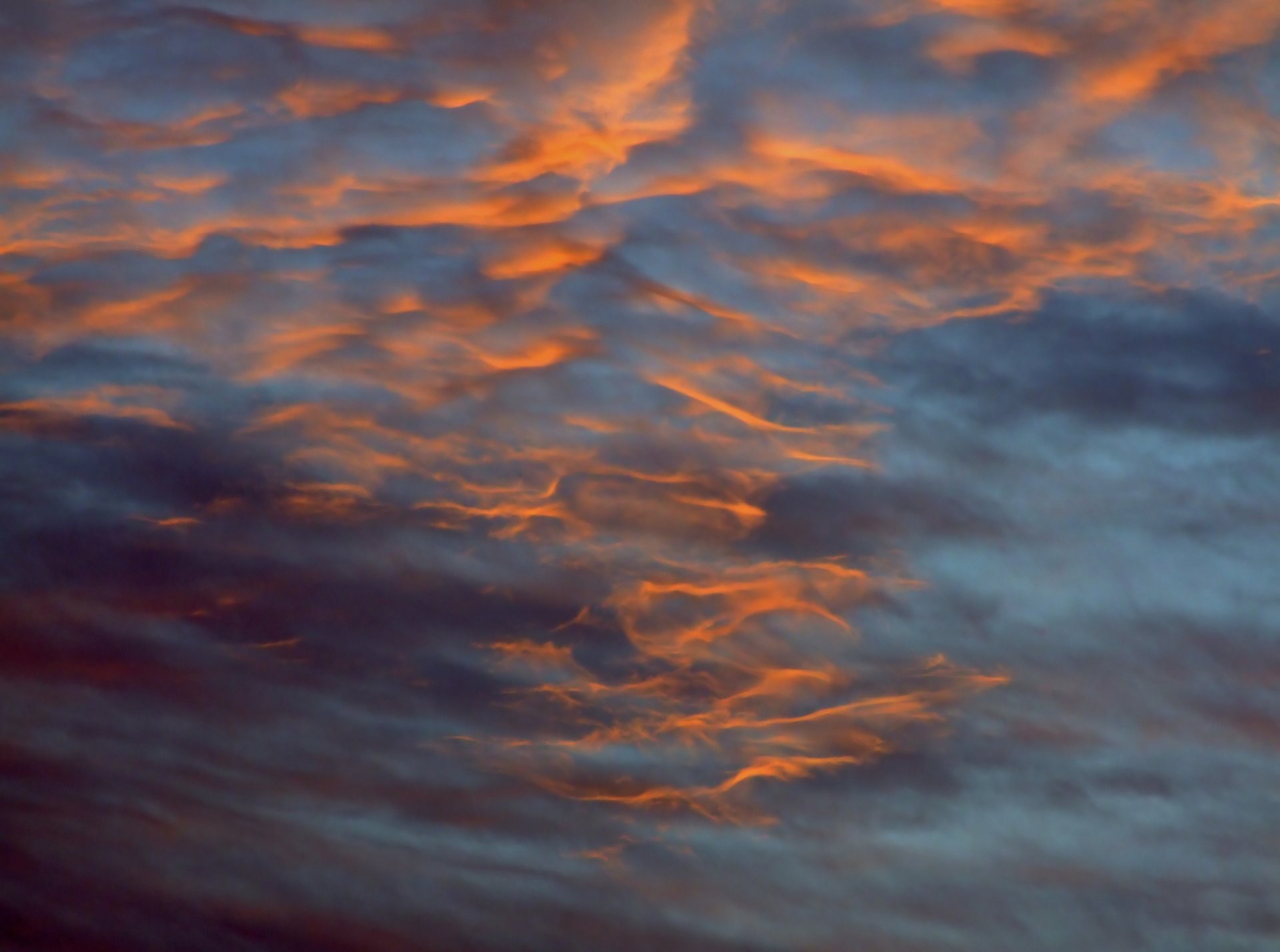 HD desktop wallpaper capturing a vibrant sky with orange and blue hues blending over a natural landscape.