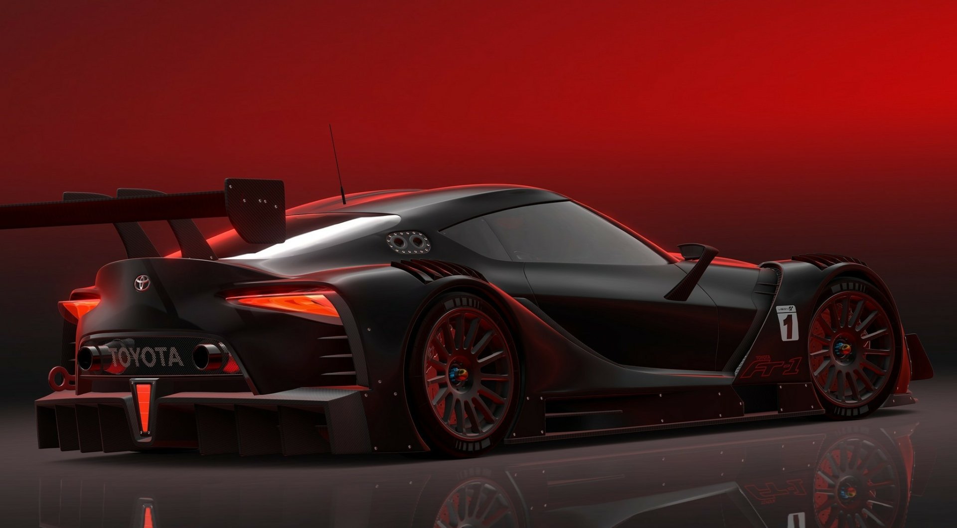 Sleek black Toyota FT-1 supercar concept with aggressive aerodynamic design, showcased against a vibrant red backdrop as an HD PC desktop wallpaper.
