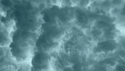 HD wallpaper featuring an overhead view of dense stormy clouds, serving as a dramatic desktop background.