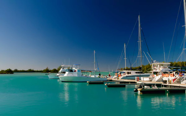 4K Ultra HD PC desktop wallpaper/background of boats (vehicle) moored in a sunlit marina over turquoise water beneath a clear blue sky.