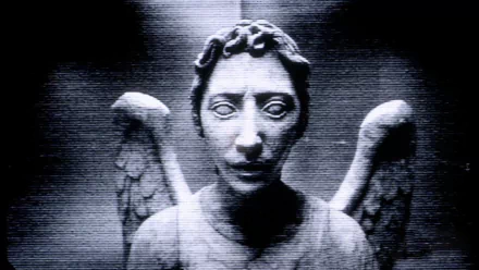 A high-definition desktop wallpaper featuring a chilling stone angel statue from the TV show Doctor Who (2005), set against a grainy, dark background.