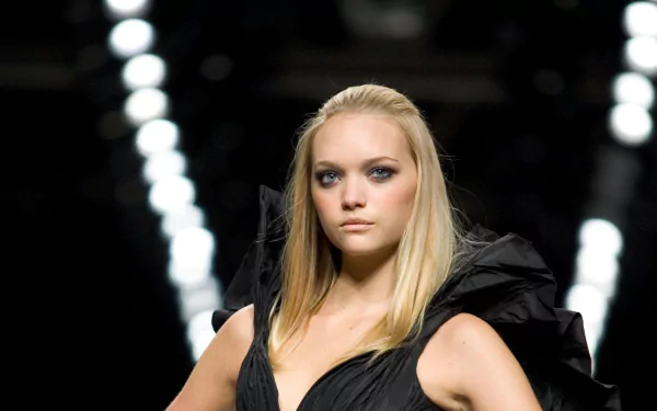 HD desktop wallpaper featuring Australian model and celebrity Gemma Ward striking a confident pose on the runway with dramatic lighting in the background.