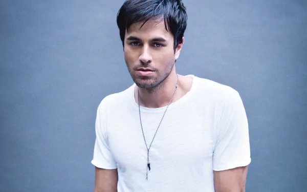 A close-up of Enrique Iglesias in a casual white shirt against a simple gray background, showcasing his stylish look in this HD PC desktop wallpaper.