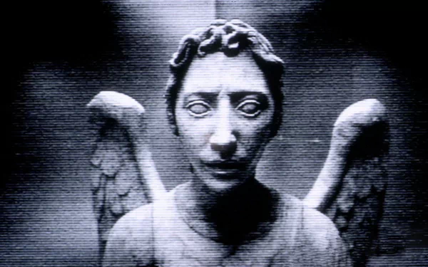 A high-definition desktop wallpaper featuring a chilling stone angel statue from the TV show Doctor Who (2005), set against a grainy, dark background.
