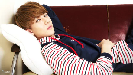 Young man in a striped hoodie, reclining on a maroon sofa with a white cushion. The image is tagged with: music, EXO. This HD desktop wallpaper and background exudes a relaxed, contemporary vibe.