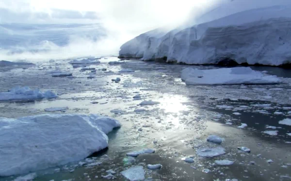 HD desktop wallpaper showcasing a serene nature scene with drifting icefloes under a cloudy sky, reflecting light on cold, tranquil waters.