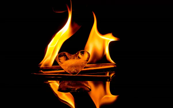 A stunning 4K Ultra HD image featuring flames dancing around a heart-shaped ice sculpture, reflecting beautifully against a dark background.