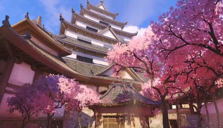 Overwatch video game HD PC desktop wallpaper: sunlit Japanese castle with tiered roofs and wooden gates, surrounded by blooming pink cherry blossoms under a bright blue sky.