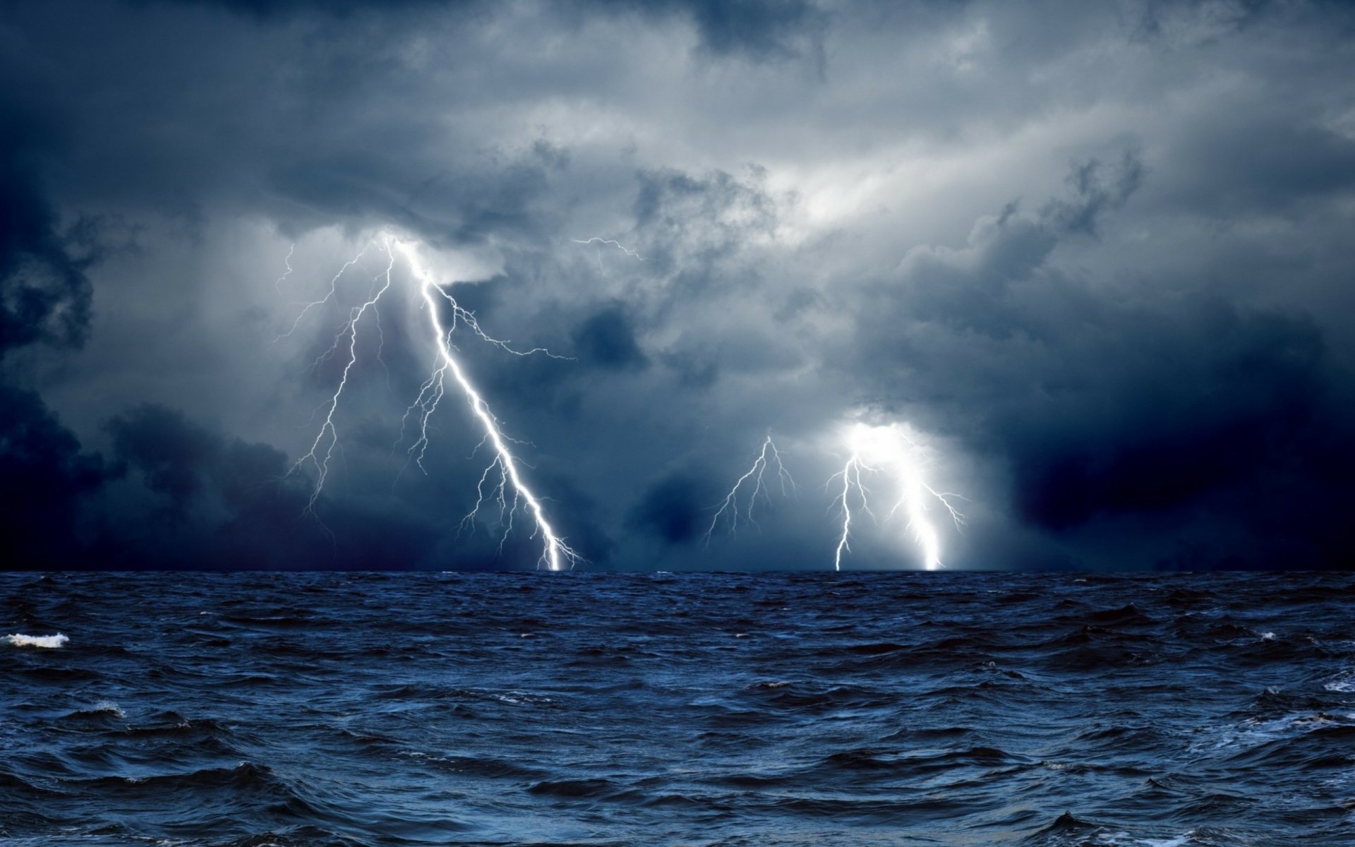 HD desktop wallpaper of a stormy sea under dark clouds with multiple striking lightning bolts illuminating the dramatic sky.