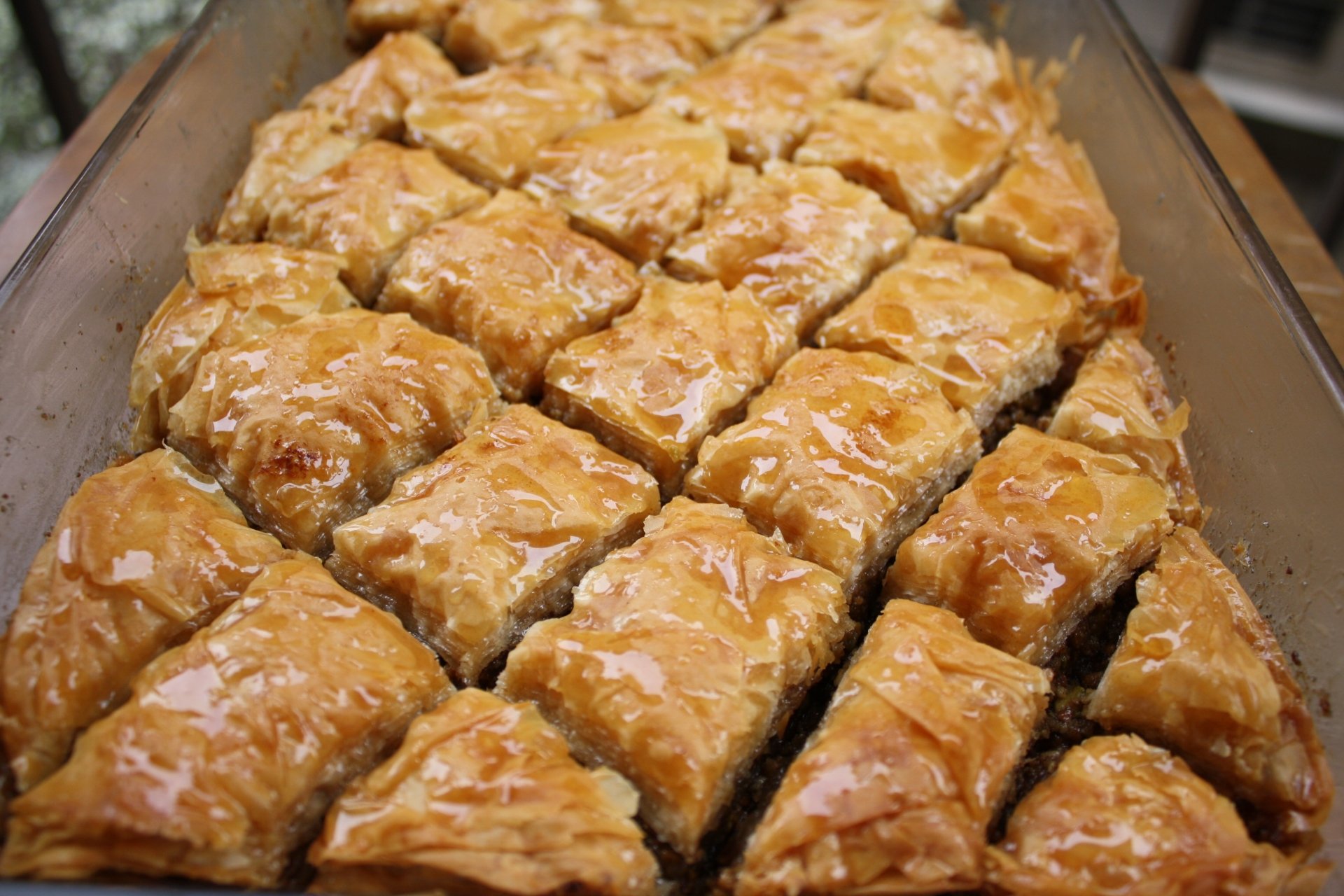 Close-up of golden glazed baklava squares with glossy honey and flaky layers in a pan — food wallpaper in 4K Ultra HD PC desktop background.