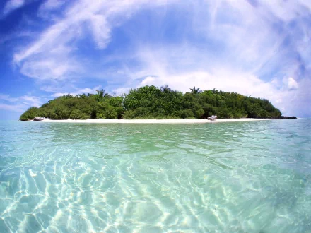 HD desktop wallpaper of a tropical island featuring lush greenery, a sandy beach, and clear turquoise waters under a vibrant blue sky with wispy clouds.