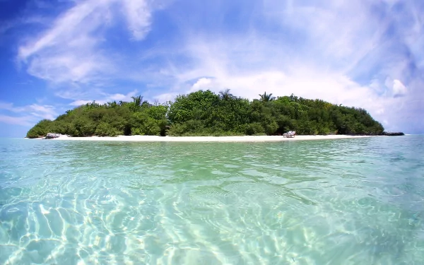 HD desktop wallpaper of a tropical island featuring lush greenery, a sandy beach, and clear turquoise waters under a vibrant blue sky with wispy clouds.