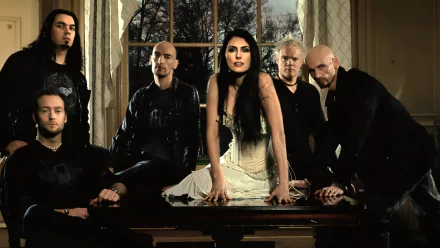 HD PC desktop wallpaper, music: symphonic rock band posed by a window, female lead in white corset center with five members around, moody gothic lighting.
