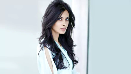 A striking HD wallpaper featuring a woman with long, flowing black hair and piercing eyes, exuding elegance and confidence. Diana Penty embodies modern beauty in this background.