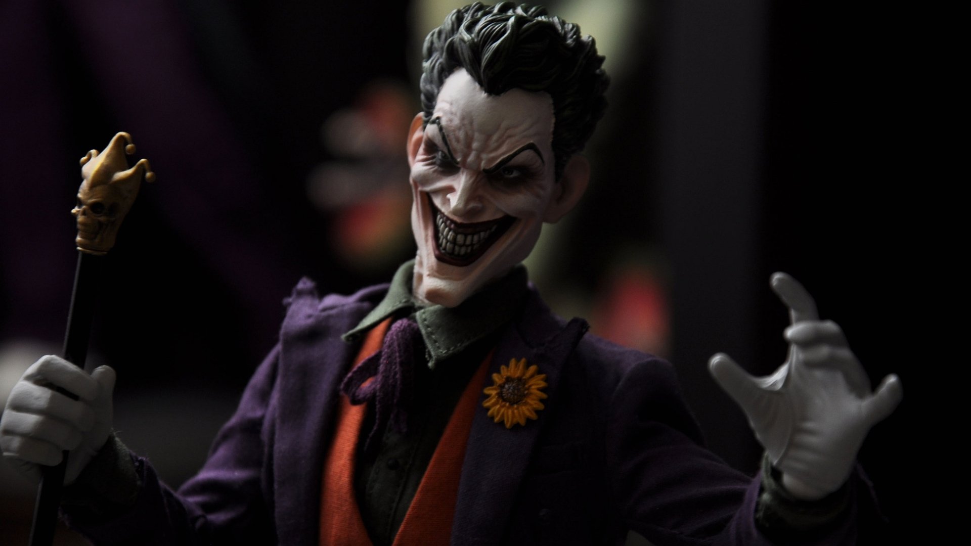 HD PC desktop wallpaper featuring a detailed comic-style Joker with a menacing grin, dressed in a purple suit and orange vest, set against a dark background.
