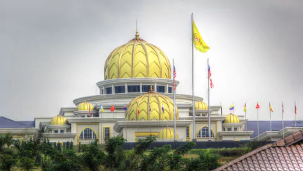 HD PC desktop wallpaper of Istana Negara, Jakarta: a man-made golden-domed presidential palace with flags and lush greenery.