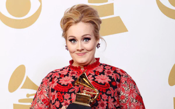 HD PC desktop wallpaper featuring British singer Adele holding a Grammy Award, dressed in a red floral outfit with a confident expression.