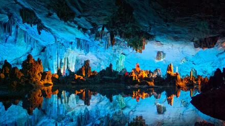 HD desktop wallpaper featuring a stunning cave with vibrant blue and orange hues, showcasing stalactites and stalagmites reflecting in a calm underground lake. Tags: nature, cave.