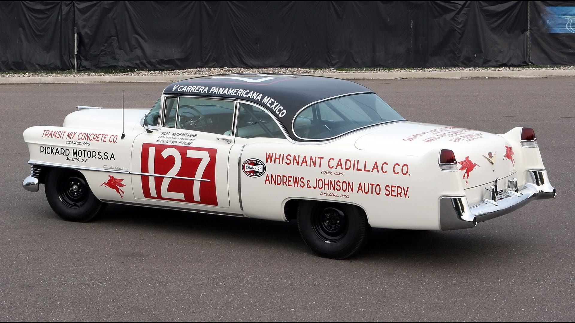 Vintage white Cadillac race car #127 with sponsor logos, shown from a rear three-quarter view on asphalt — HD PC desktop wallpaper and background.