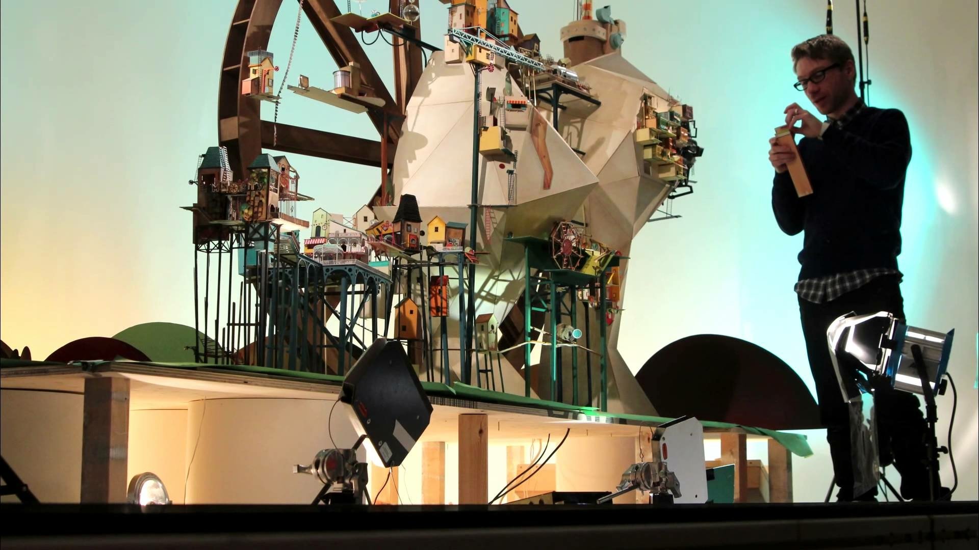 HD desktop wallpaper of Lumino City with a man presenting a detailed model of the whimsical game environment.