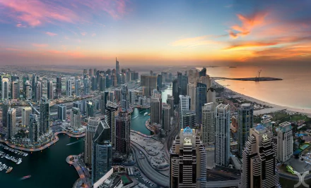 HD desktop wallpaper: Dubai Marina at sunset — United Arab Emirates skyline of man-made skyscrapers along the waterfront with a glowing sky and Gulf horizon.