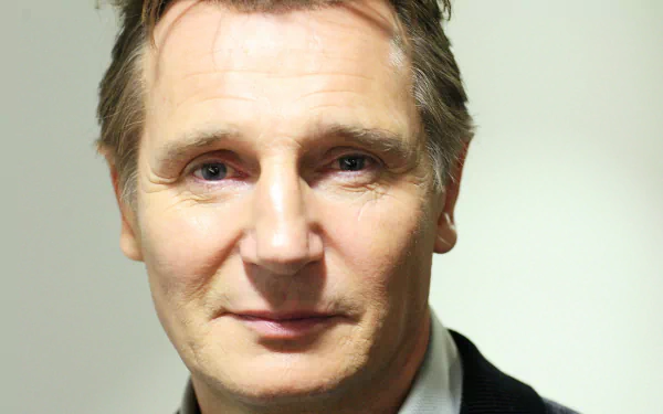 HD desktop wallpaper featuring a close-up of a man resembling Liam Neeson in a suit with a focused expression.