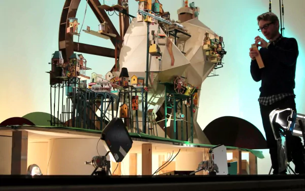 HD desktop wallpaper of Lumino City with a man presenting a detailed model of the whimsical game environment.