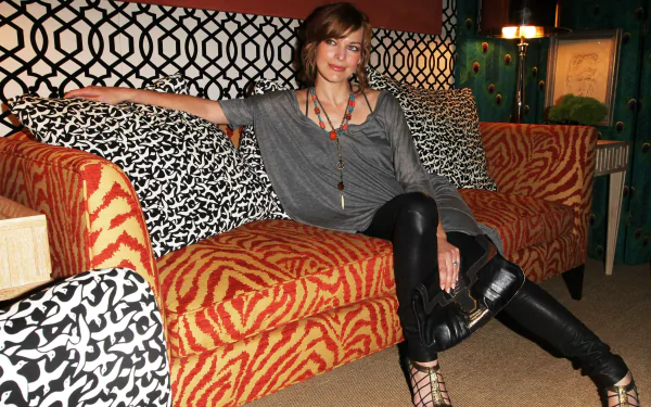 Portrait of a celebrity seated on a bold patterned sofa in an eclectic room — 4K Ultra HD PC desktop wallpaper/background.