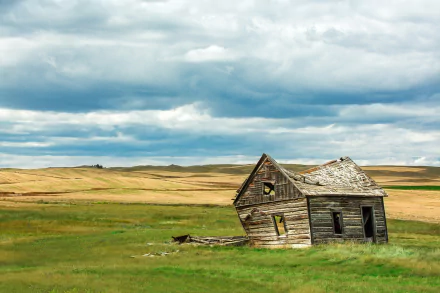 HD PC desktop wallpaper and background: a man-made wooden cabin leaning in wide grassy plains beneath a dramatic, cloud-filled sky.