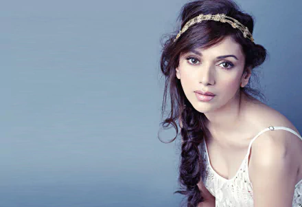 HD desktop wallpaper featuring celebrity Aditi Rao Hydari in a graceful pose, wearing a delicate headpiece and white outfit against a soft blue background.