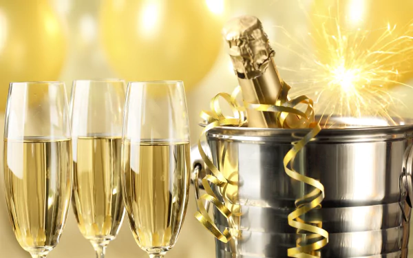 Holiday New Year 5K Ultra HD PC desktop wallpaper and background: three champagne flutes, a champagne bottle in an ice bucket with gold ribbons, a lit sparkler and golden balloons.