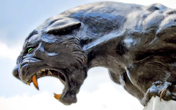 A striking close-up of a black panther, showcasing its fierce expression and powerful features. This HD wallpaper adds a dramatic touch to any desktop background.