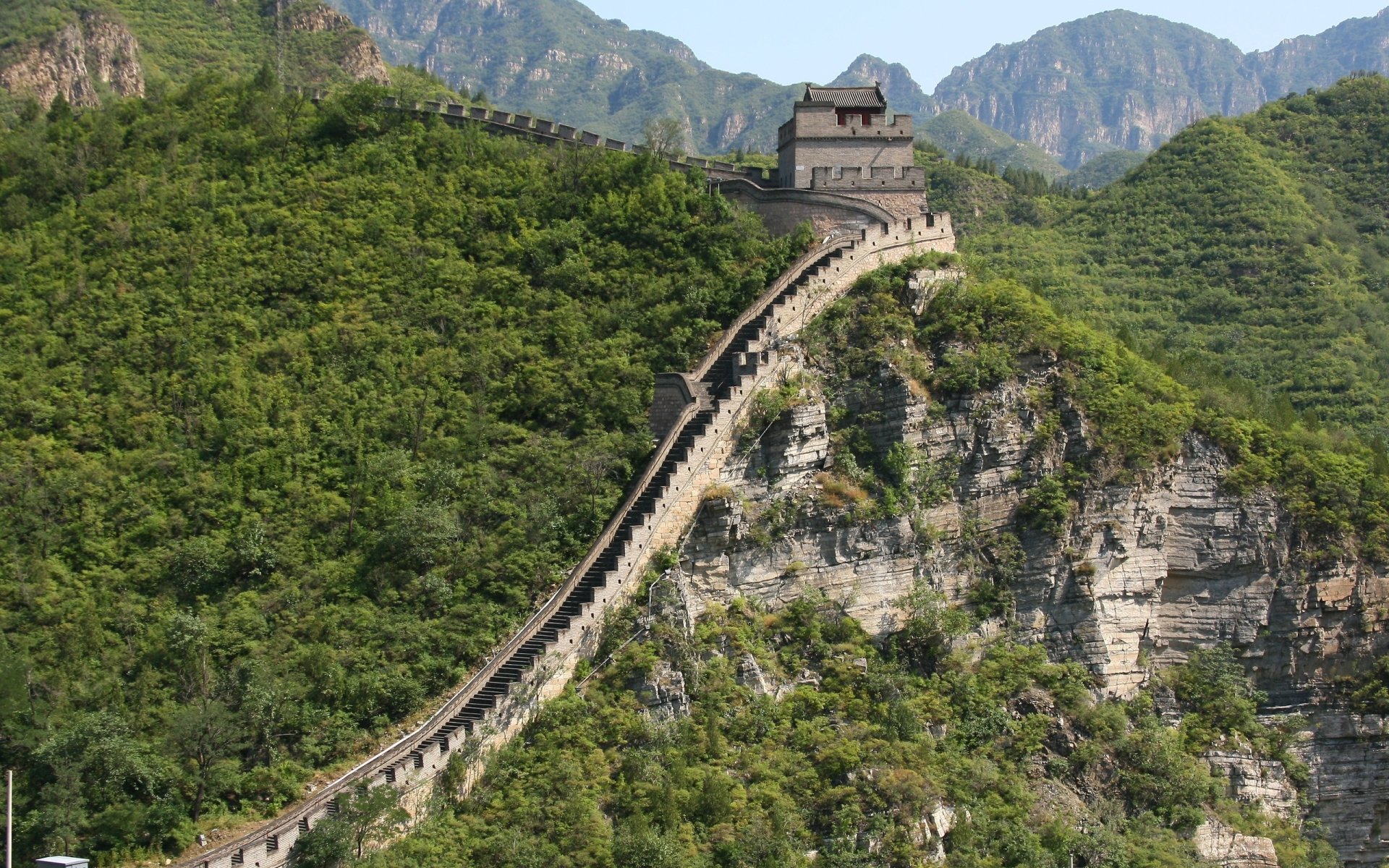 Man-made Great Wall of China snaking over green mountain ridges with a watchtower, high-resolution 2K Quad HD PC desktop wallpaper background.