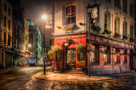 A vibrant London pub illuminated at night, nestled in a quiet street. The charming architecture and warm glow create a captivating scene in this bustling city.