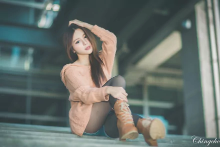 A Taiwanese woman, Julie Chang, poses stylishly in a soft sweater and knee-high boots, creating a captivating 4K Ultra HD desktop wallpaper.