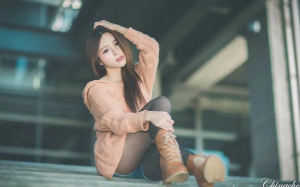 A Taiwanese woman, Julie Chang, poses stylishly in a soft sweater and knee-high boots, creating a captivating 4K Ultra HD desktop wallpaper.