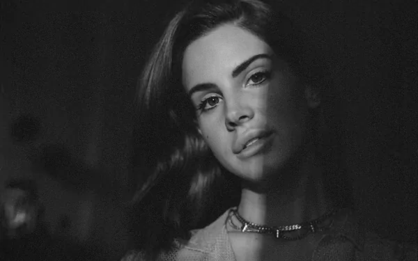 Black and white HD desktop wallpaper featuring a close-up portrait of Lana Del Rey, capturing her serene expression in soft lighting.