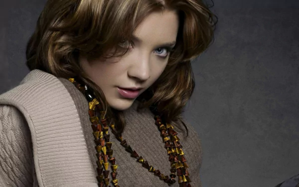HD PC desktop wallpaper featuring celebrity Natalie Dormer with a contemplative expression, styled hair, and layered clothing against a dark background.