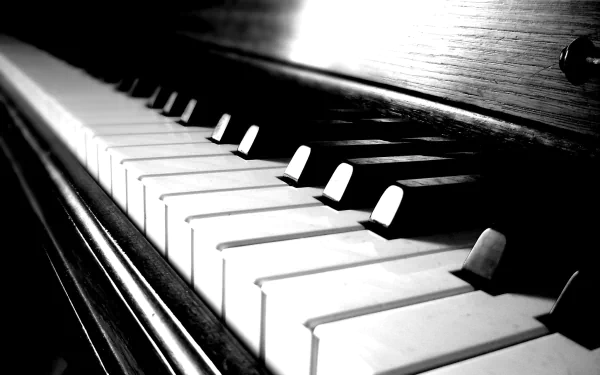 HD desktop wallpaper showcasing a close-up, black-and-white view of piano keys, highlighting the elegance of music and the instrument's texture.