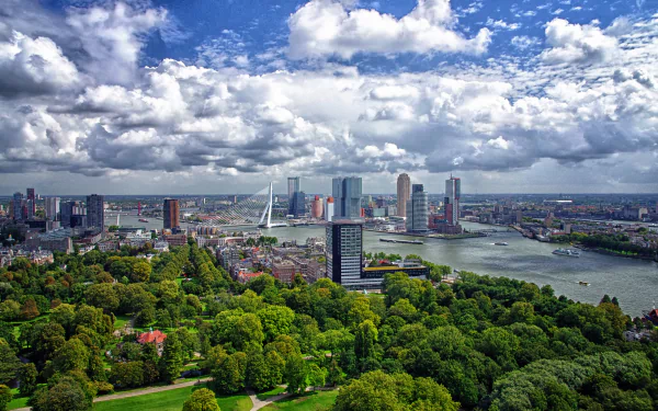 A stunning view of Rotterdam's harbor, featuring a vibrant skyline under a cloudy sky, surrounded by lush greenery and a winding river, captured in 4K Ultra HD.