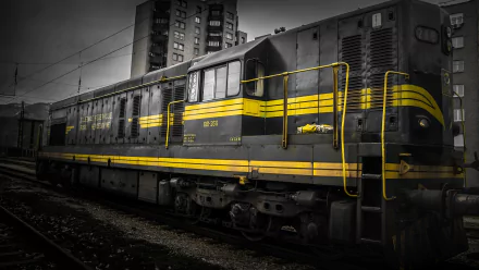 HD PC desktop wallpaper featuring a vintage train with yellow stripes, set against urban buildings in a dramatic black-and-white style.