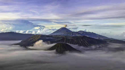 A breathtaking view of Mount Bromo in Java, Indonesia, surrounded by mist and dramatic clouds, showcasing the beauty of nature in this stunning HD wallpaper.