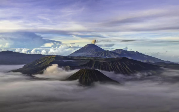 A breathtaking view of Mount Bromo in Java, Indonesia, surrounded by mist and dramatic clouds, showcasing the beauty of nature in this stunning HD wallpaper.