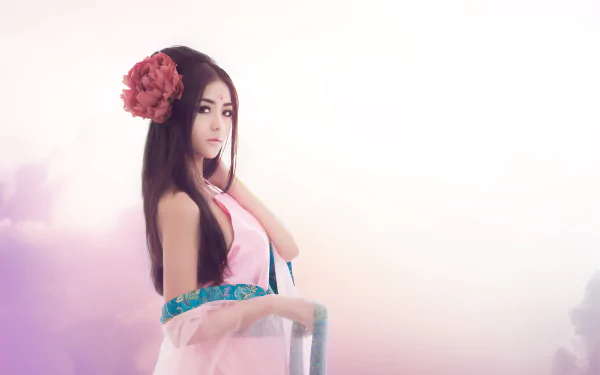 HD desktop wallpaper featuring a Vietnamese woman with long hair adorned with a large pink flower, dressed in traditional attire against a soft, pastel background.
